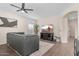 Living room with sectional, large TV, wood floors, and natural light at 1574 E Scott Ave, Gilbert, AZ 85234