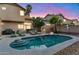 Relaxing backyard pool area with lush landscaping, lounge chairs, and outdoor kitchen island at dusk at 1574 E Scott Ave, Gilbert, AZ 85234