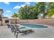 Private backyard pool area with a built-in fireplace and comfortable lounge seating at 1574 E Scott Ave, Gilbert, AZ 85234