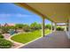 An extended covered patio with lush landscaping, a nice lawn, and desert accents at 16729 W Alvarado Dr, Goodyear, AZ 85395