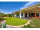 Lovely backyard featuring green artificial turf, a covered patio, and a beautifully landscaped border at 16729 W Alvarado Dr, Goodyear, AZ 85395