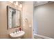 Powder room featuring a pedestal sink, framed mirror, and neutral color scheme at 16729 W Alvarado Dr, Goodyear, AZ 85395
