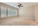 Bedroom with neutral carpet, shuttered windows, and ceiling fan at 16729 W Alvarado Dr, Goodyear, AZ 85395