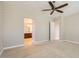 Bedroom with neutral walls and carpet, ceiling fan, and view to bathroom at 16729 W Alvarado Dr, Goodyear, AZ 85395