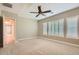 Spacious bedroom with neutral carpet, shuttered windows, and ceiling fan at 16729 W Alvarado Dr, Goodyear, AZ 85395