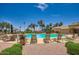 View of the community pool with lounge chairs, shaded areas, and palm trees around the perimeter at 16729 W Alvarado Dr, Goodyear, AZ 85395