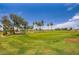 Scenic golf course view with lush green grass, mature trees, and players enjoying a round at 16729 W Alvarado Dr, Goodyear, AZ 85395