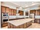 Gourmet kitchen with wood cabinets, large island and stainless steel appliances at 16729 W Alvarado Dr, Goodyear, AZ 85395