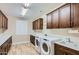 A laundry room featuring wooden cabinets, counters, and a washer and dryer at 16729 W Alvarado Dr, Goodyear, AZ 85395