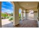 Covered porch with stone flooring and open views of the landscaped yard at 16729 W Alvarado Dr, Goodyear, AZ 85395