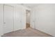 Bedroom featuring carpeting, closet doors and a view to the hall at 18262 W La Senda Dr, Surprise, AZ 85387