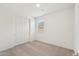 Cozy bedroom with neutral carpet, a window with blinds, and a closet for ample storage at 18262 W La Senda Dr, Surprise, AZ 85387