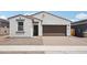 Inviting single-story home featuring a brick driveway and a two-car garage with eye-catching, contrasting trim at 18262 W La Senda Dr, Surprise, AZ 85387