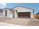 Charming single-story home with a brick driveway and two-car garage beneath a clear, blue sky at 18262 W La Senda Dr, Surprise, AZ 85387