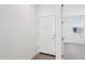 Simple, bright entrance with a white door and light wood-look flooring leading into the main living space at 18268 W La Senda Dr, Surprise, AZ 85387