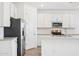 Bright kitchen with stainless steel appliances, white cabinets, a center island, and modern finishes at 18268 W La Senda Dr, Surprise, AZ 85387