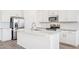 Close-up of a kitchen with stainless steel appliances, white cabinets, tile backsplash, and a center island at 18268 W La Senda Dr, Surprise, AZ 85387