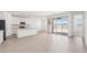 Bright living room featuring modern wood-look tile flooring, an open floor plan, and sliding glass doors to the backyard at 18268 W La Senda Dr, Surprise, AZ 85387
