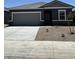 View of a modern home with a gray exterior, two-car garage, and simple desert landscaping at 1985 E Bucking Bronco Dr, San Tan Valley, AZ 85140