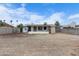 Wide shot of the spacious backyard and home during the day under a blue sky at 2002 W Windrose Dr, Phoenix, AZ 85029