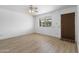 Cozy bedroom with a ceiling fan, neutral walls, and wood-look laminate flooring at 2002 W Windrose Dr, Phoenix, AZ 85029