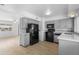A well-lit kitchen features new laminate flooring, gray cabinets, and black appliances at 2002 W Windrose Dr, Phoenix, AZ 85029