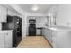 A well-lit kitchen features new laminate flooring, gray cabinets, and black appliances at 2002 W Windrose Dr, Phoenix, AZ 85029