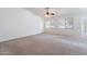 Inviting living room with fresh paint, carpet, ceiling fan, and windows letting in natural light at 2024 W Darrel Rd, Phoenix, AZ 85041