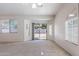 Bright living room with neutral colors, large windows, and slider to backyard with mature landscaping at 2024 W Darrel Rd, Phoenix, AZ 85041