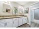 Bright bathroom featuring double sinks, granite countertop, white cabinets, and a glass-enclosed shower at 2301 E Sunnyside Dr, Phoenix, AZ 85028