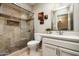 Elegant bathroom with a travertine tile shower, glass door, and a modern vanity with sink at 2301 E Sunnyside Dr, Phoenix, AZ 85028
