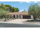 Charming home with arched entryway, desert landscaping, and a spacious driveway leading to a garage at 2301 E Sunnyside Dr, Phoenix, AZ 85028