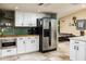Well-equipped kitchen with stainless steel refrigerator, white cabinets, and wood countertops at 2301 E Sunnyside Dr, Phoenix, AZ 85028