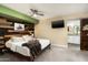 Modern main bedroom with stylish wood accent wall, mounted TV, and barn door to the bathroom at 2301 E Sunnyside Dr, Phoenix, AZ 85028