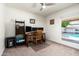 Bright home office with a wooden desk, multiple monitors, and a window overlooking the pool at 2301 E Sunnyside Dr, Phoenix, AZ 85028