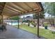 Large covered patio overlooking a pool and landscaped backyard with lounge furniture and an outdoor dining area at 2301 E Sunnyside Dr, Phoenix, AZ 85028
