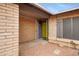 A gated entrance showcases a bright yellow door and neutral brick finishes at 3106 S Extension Rd, Mesa, AZ 85210