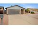 Charming brick home with a gray garage door, desert landscape, and mature palm trees at 3106 S Extension Rd, Mesa, AZ 85210