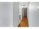 Hallway with neutral walls leads to bathroom with wood-look flooring and gray doors at 3106 S Extension Rd, Mesa, AZ 85210
