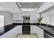 Bright kitchen featuring stainless appliances, white cabinets, and dark countertops creating a stylish and functional cooking space at 3106 S Extension Rd, Mesa, AZ 85210