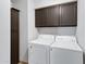Laundry room with washer, dryer, and overhead cabinets at 3106 S Extension Rd, Mesa, AZ 85210