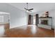 Open living room features a brick fireplace, ceiling fan, and wood flooring at 3106 S Extension Rd, Mesa, AZ 85210