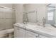 Bathroom featuring double sinks with marble countertop, a glass enclosed shower, and a toilet at 35314 N 31St Ave, Phoenix, AZ 85086