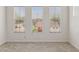 Bright bedroom with neutral carpet, three windows, and a view of lush greenery at 35314 N 31St Ave, Phoenix, AZ 85086