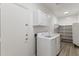 Bright laundry room with shelving, white cabinets, and new white washer and dryer at 35314 N 31St Ave, Phoenix, AZ 85086