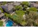 Aerial view of a backyard with a sparkling pool surrounded by mature trees and lush greenery at 3818 E Quail Ave, Phoenix, AZ 85050