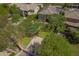 Aerial view of a lush backyard featuring a pool, basketball court, mature trees, and a well-manicured lawn at 3818 E Quail Ave, Phoenix, AZ 85050