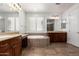 Bathroom featuring a large soaking tub with tile surround and dual vanities at 3818 E Quail Ave, Phoenix, AZ 85050