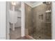 Tiled shower in bathroom with glass door and built-in bench, with walk-in closet in background at 3818 E Quail Ave, Phoenix, AZ 85050