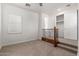 Carpeted room featuring a window, steps with railing, and a walk-in closet with sliding doors at 3818 E Quail Ave, Phoenix, AZ 85050
